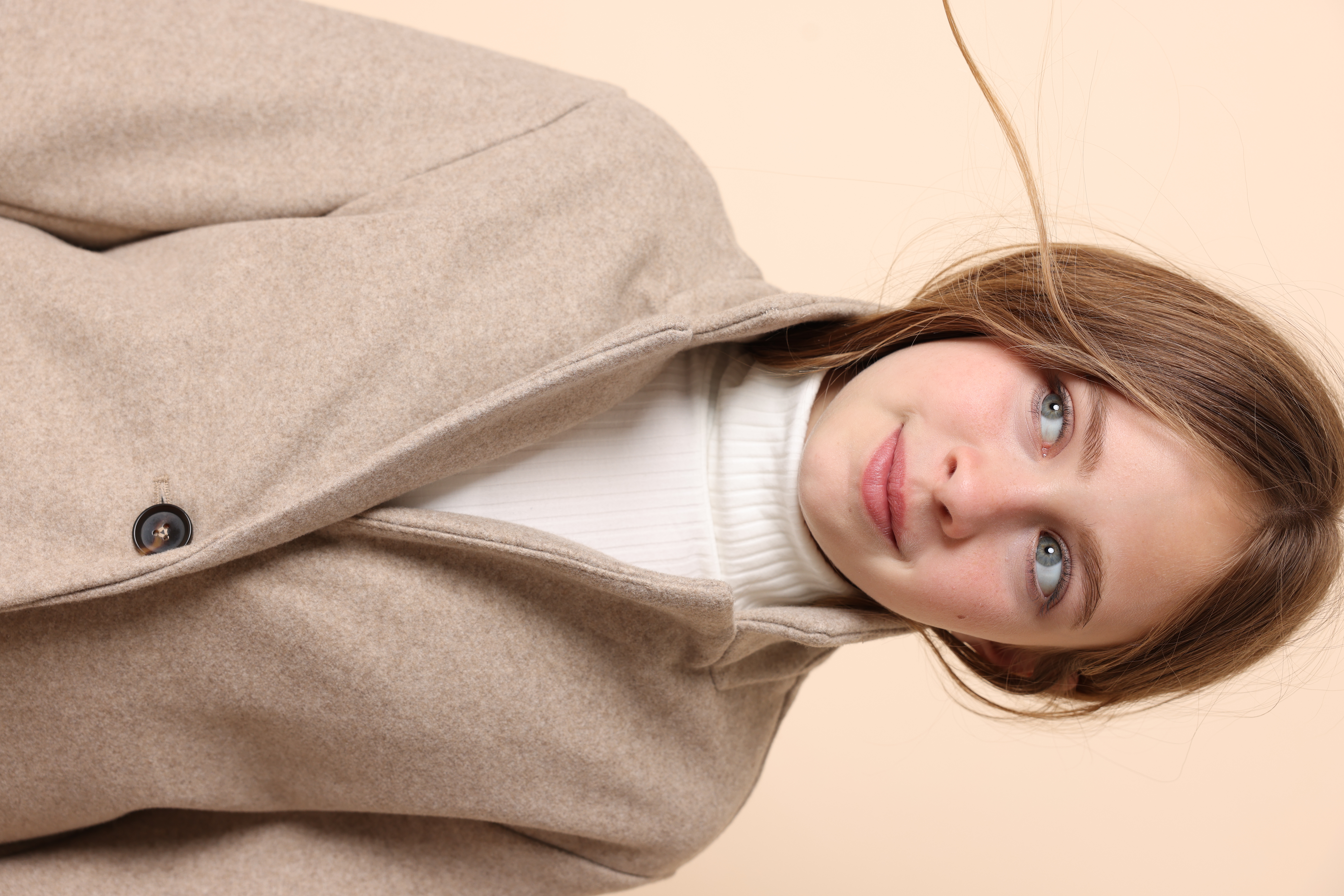 Chloe smiling in a beige coat